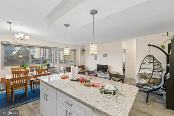 a kitchen with granite countertop a dining table chairs and a floor to ceiling window