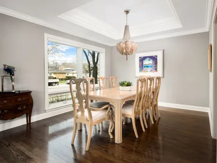 a kitchen with a dining table chairs and white cabinets