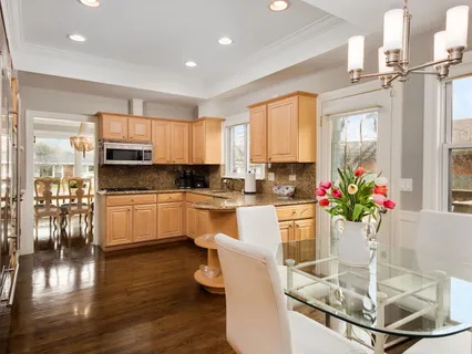 a kitchen with stainless steel appliances granite countertop a refrigerator a stove and a sink with wooden floor