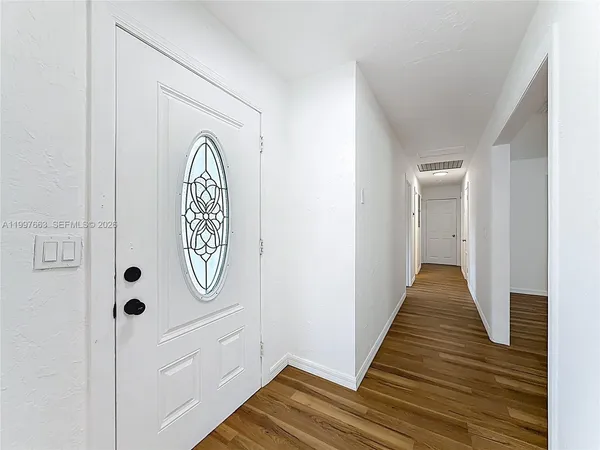 a view of a hallway with wooden floor