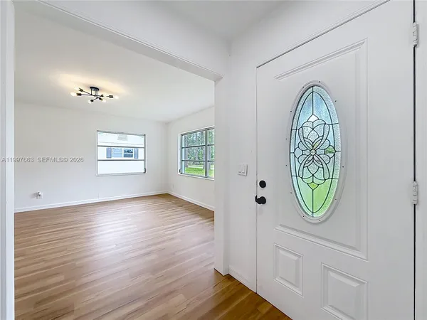 a view of an empty room with wooden floor