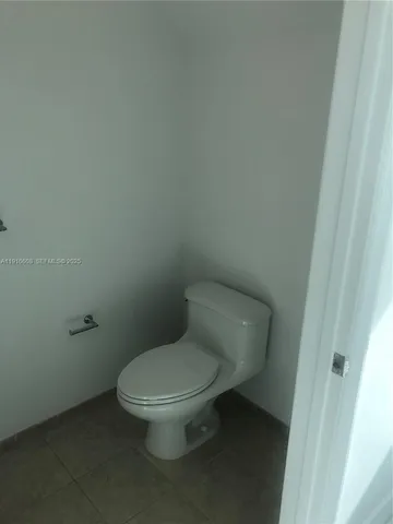 a white toilet sitting next to a white cabinet