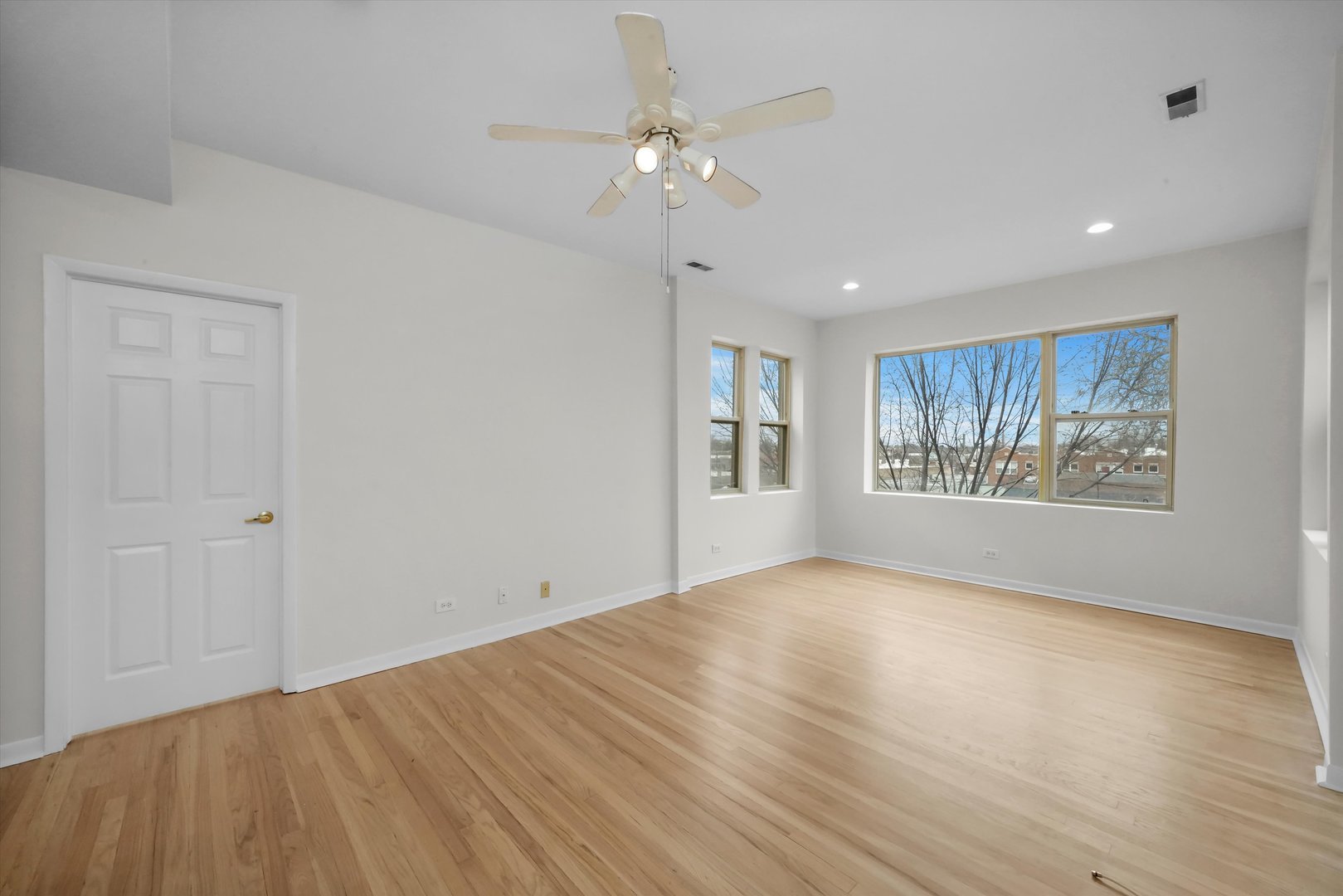 4845 North Harding Avenue, Unit 3 Chicago, IL 60625 - Photo 3 of 17 a view of an empty room with a window and wooden floor