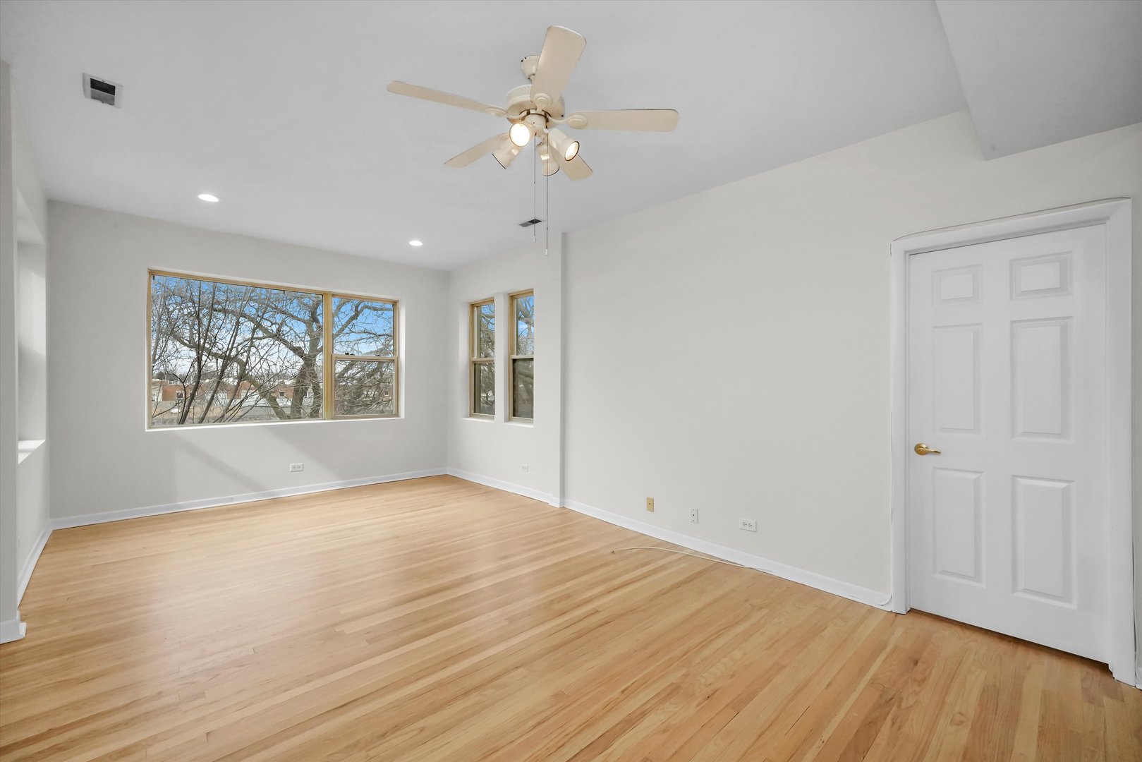4845 North Harding Avenue, Unit 3 Chicago, IL 60625 - Photo 4 of 17 a view of an empty room with a window and wooden floor