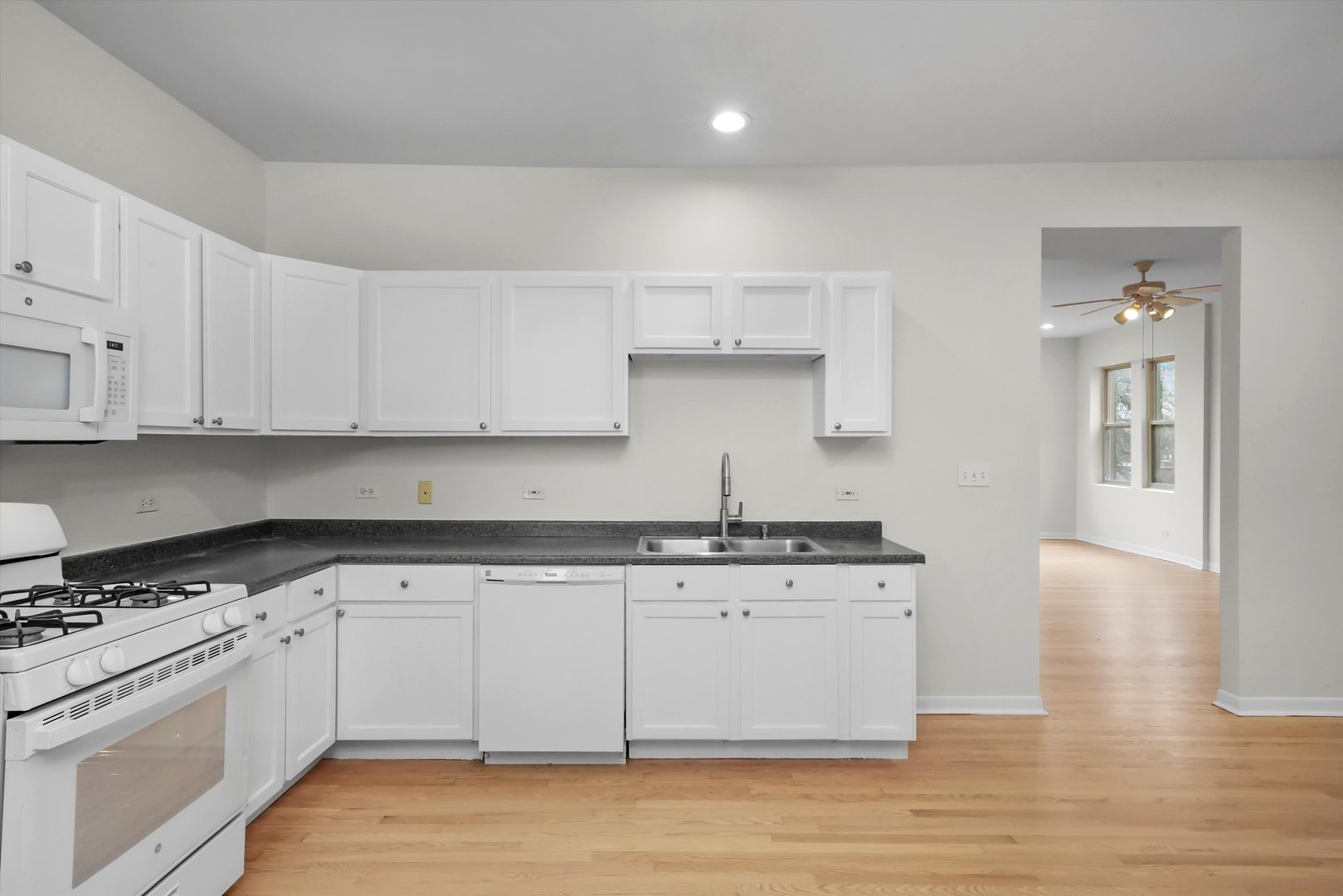4845 North Harding Avenue, Unit 3 Chicago, IL 60625 - Photo 7 of 17 a kitchen with stainless steel appliances granite countertop a stove a sink and white cabinets