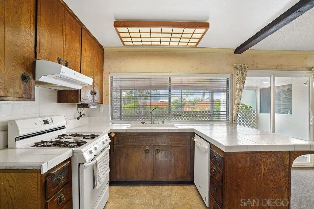 750 Kostner Drive San Diego, CA 92154 - Photo 17 of 34 a kitchen with a stove a sink and a wooden cabinets
