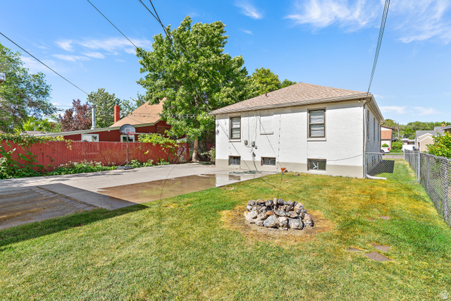372 800 East Provo, UT 84606 - Photo 29 of 29 Expansive backyard featuring a lush lawn, stone fire pit, and a paved patio area