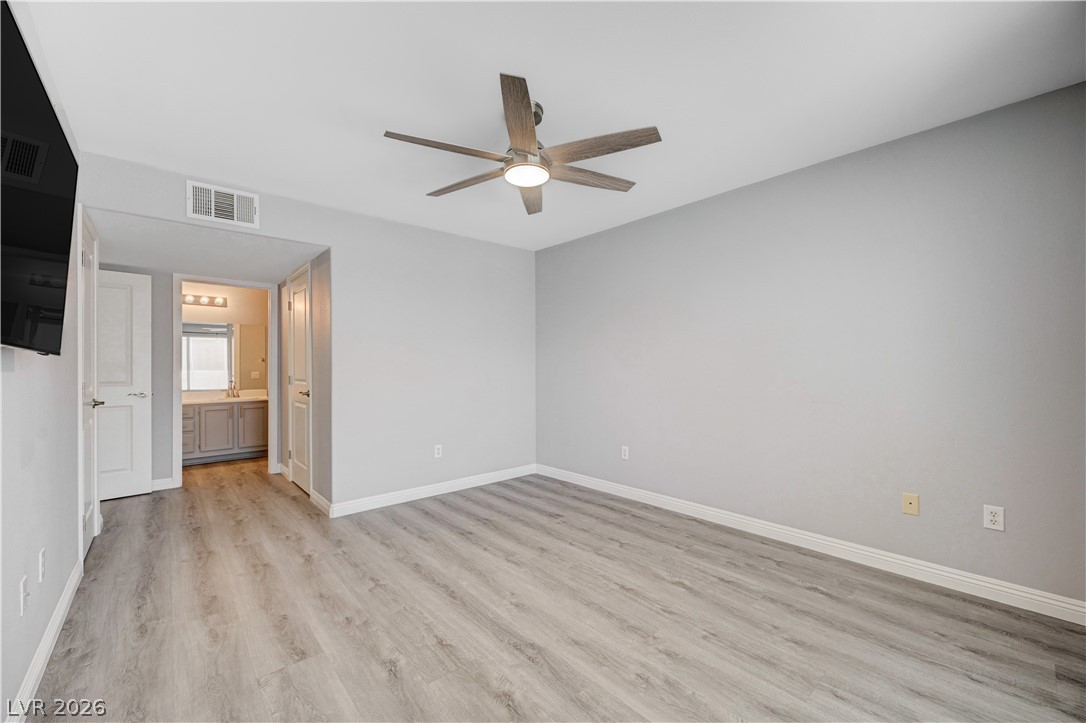 3425 East Russell Road, Unit 223 Las Vegas, NV 89120 - Photo 21 of 47 A well-lit bedroom with modern flooring and direct access to a private bathroom.