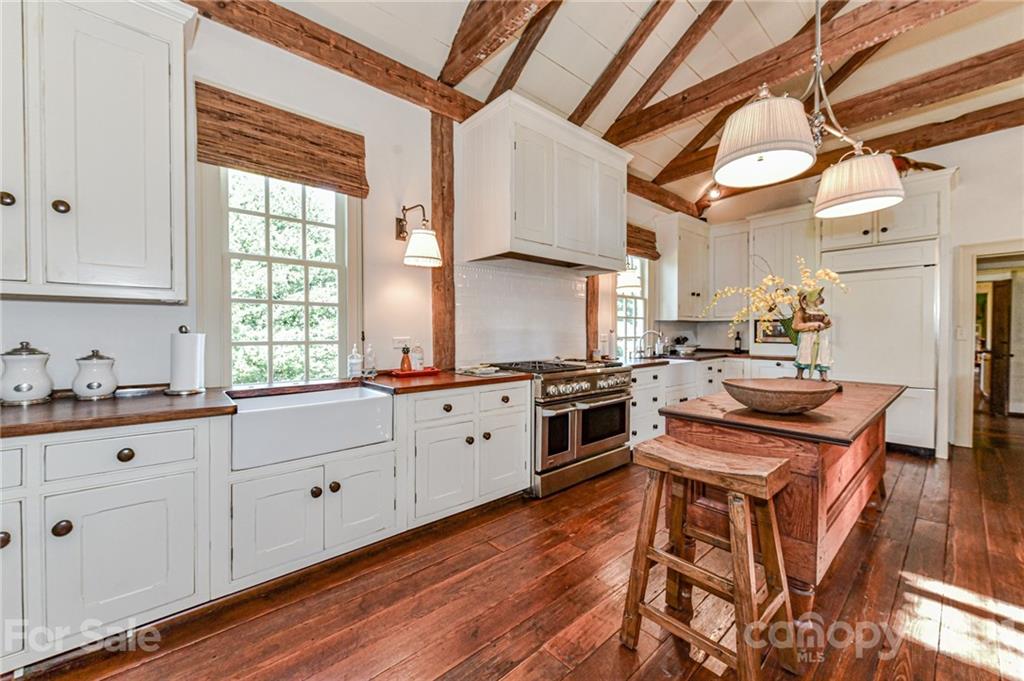 2539 Wooten Road Chester, SC 29706 - Photo 14 of 46 a kitchen with stainless steel appliances granite countertop a stove a sink and white cabinets with wooden floor