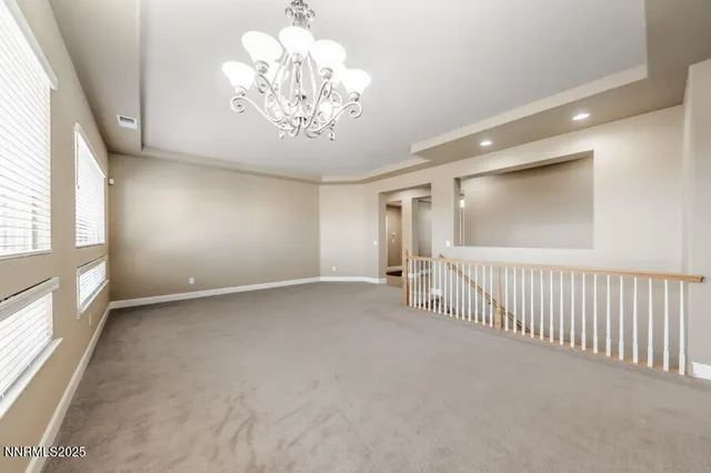 en empty room with windows and chandelier