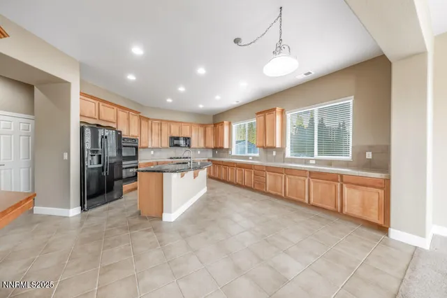 a large kitchen with a large counter top stainless steel appliances and cabinets