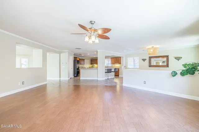 an empty room with a window and a fan