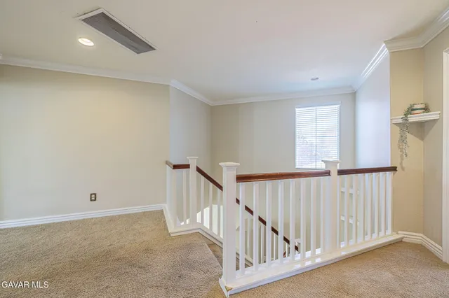 an empty room with windows and ceiling fan