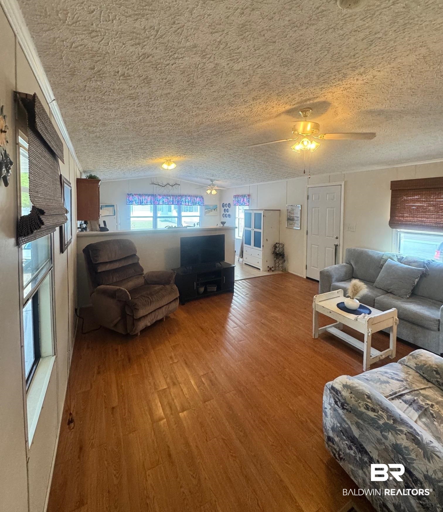 1936 Ridgewood Drive Lillian, AL 36549 - Photo 4 of 30 Living room with a textured ceiling, a ceiling fan, and wood finished floors