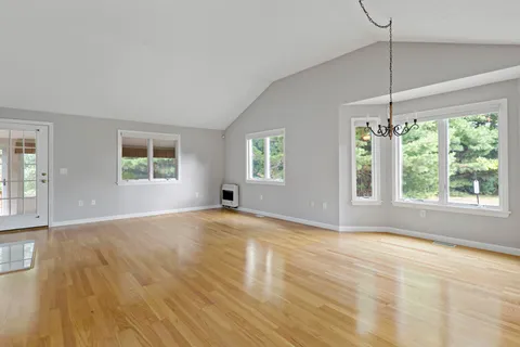 a view of empty room with wooden floor and fireplace