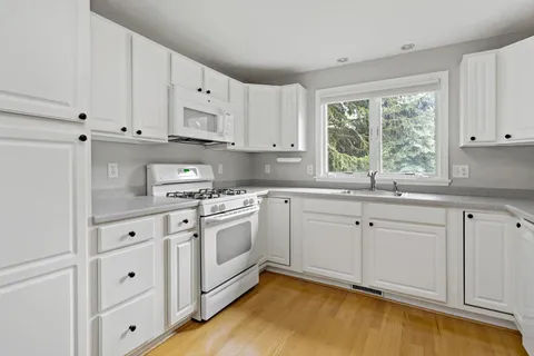 a view of a kitchen with a sink cabinets and wooden floor
