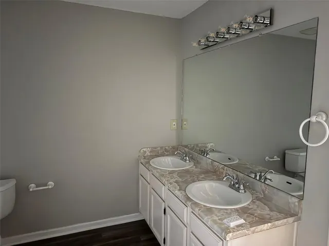 a bathroom with a granite countertop sink a toilet and a mirror