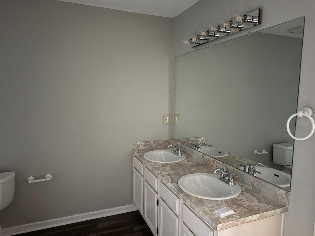 167 Merlin Way Euless, TX 76039 - Photo 12 of 18 a bathroom with a granite countertop sink a toilet and a mirror