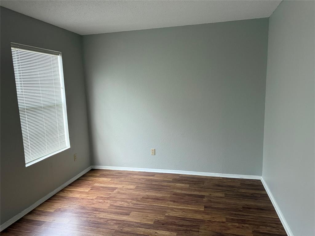 167 Merlin Way Euless, TX 76039 - Photo 8 of 18 a view of an empty room with wooden floor and a window