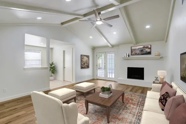 a living room with furniture a flat screen tv and a fireplace