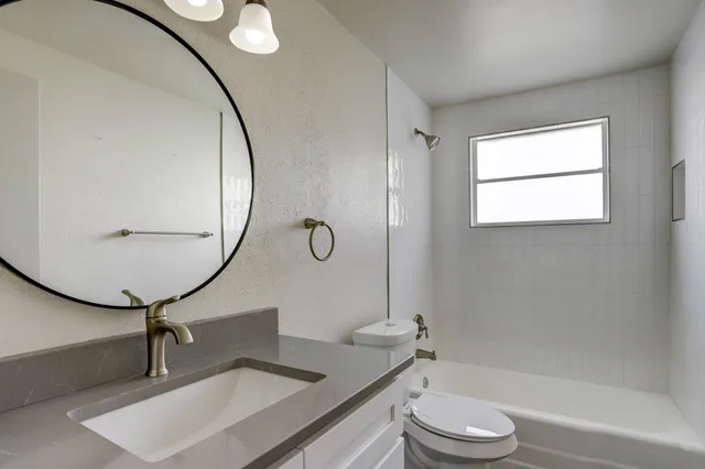 a bathroom with a toilet a sink and mirror