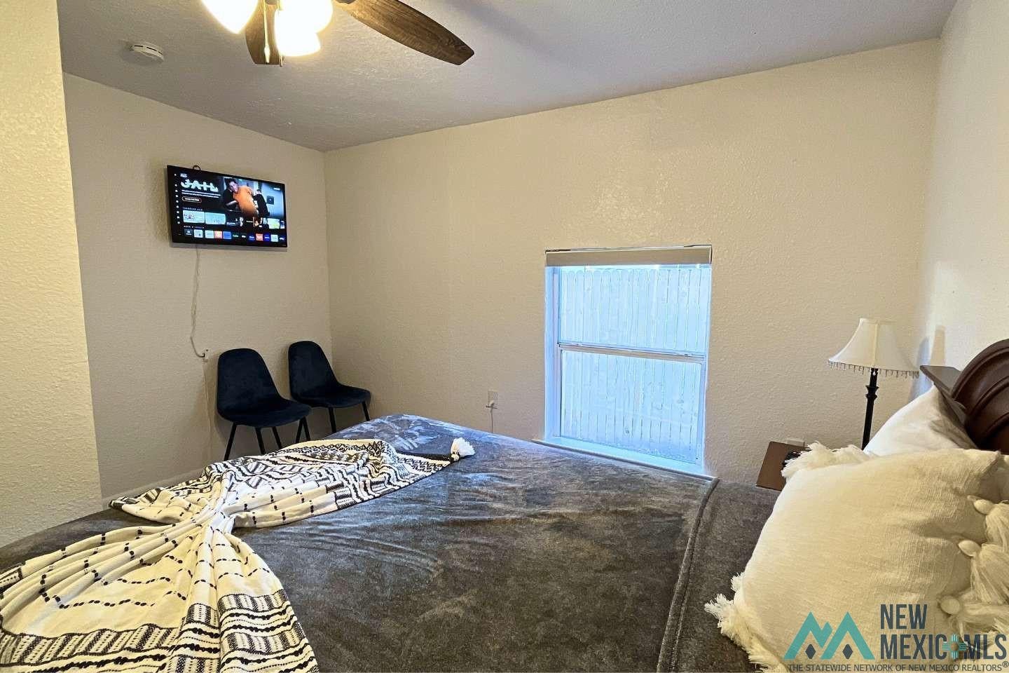 241 Junction Road Ruidoso, NM 88345 - Photo 28 of 44 Bedroom with a textured wall, ceiling fan, and a textured ceiling