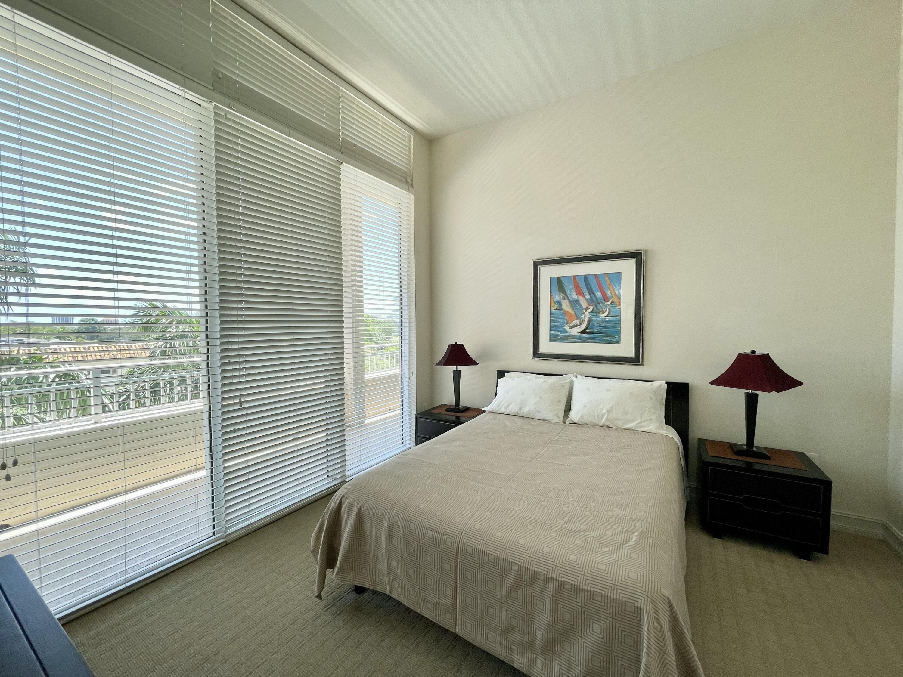 99 Southeast Mizner Boulevard, Unit 509 Boca Raton, FL 33432 - Photo 13 of 28 a bed room with a bed and a lamp