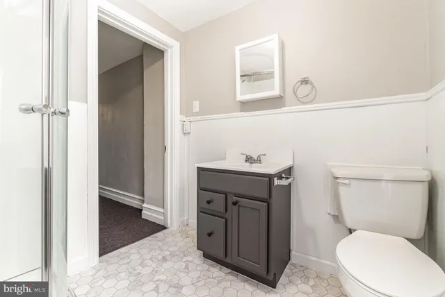a bathroom with a toilet a sink and mirror