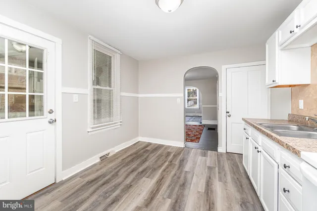 a view of a kitchen with a sink wooden cabinets and a window