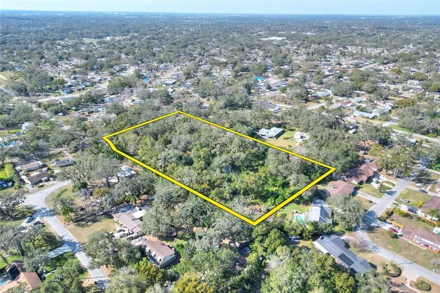 an aerial view of residential houses with outdoor space and trees