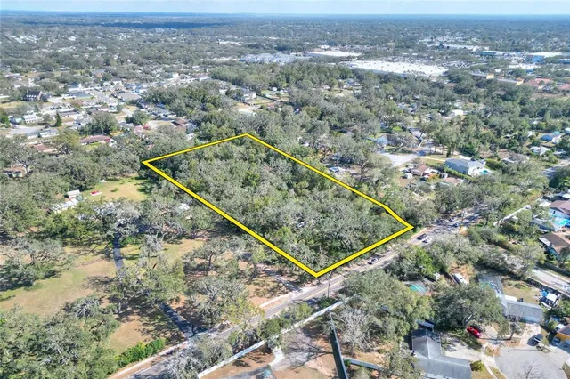 an aerial view of residential houses with outdoor space and trees