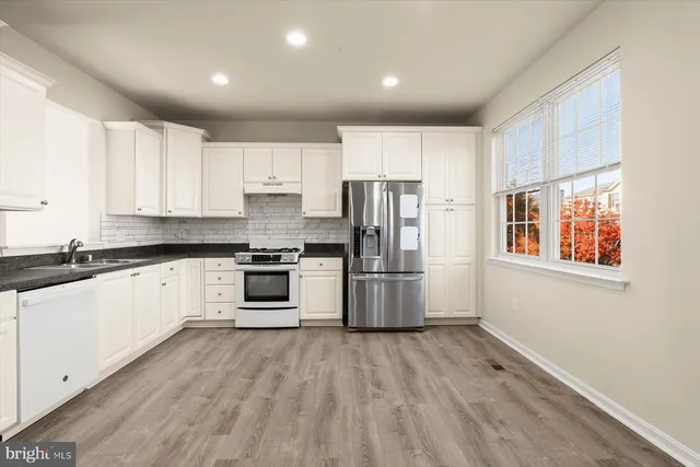 a kitchen with stainless steel appliances a refrigerator and a stove top oven