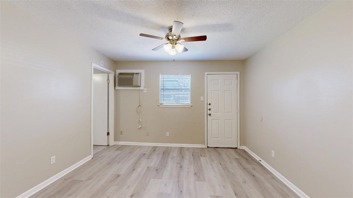 500 Foch Street, Unit 16 Bryan, TX 77801 - Photo 3 of 15 an empty room with wooden floor ceiling fan and windows