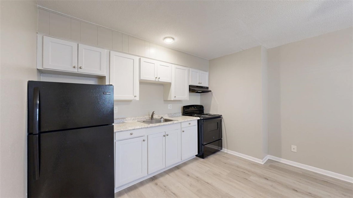 500 Foch Street, Unit 16 Bryan, TX 77801 - Photo 4 of 15 a kitchen with a sink a refrigerator and cabinets