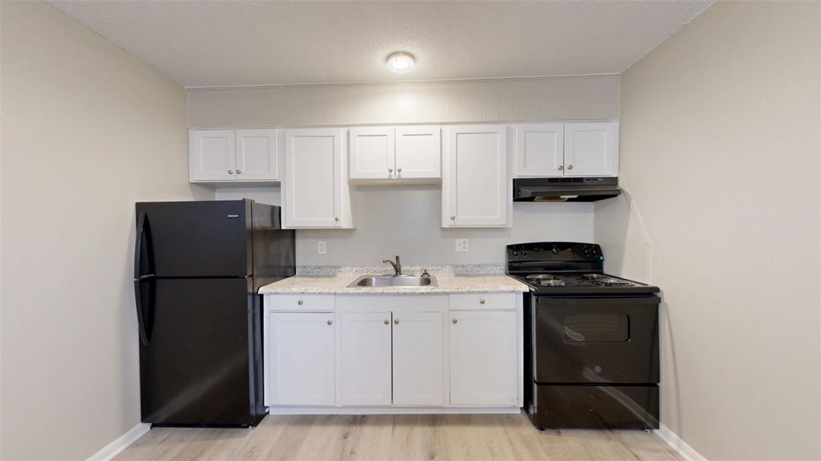 500 Foch Street, Unit 16 Bryan, TX 77801 - Photo 5 of 15 a kitchen with a sink a stove and refrigerator