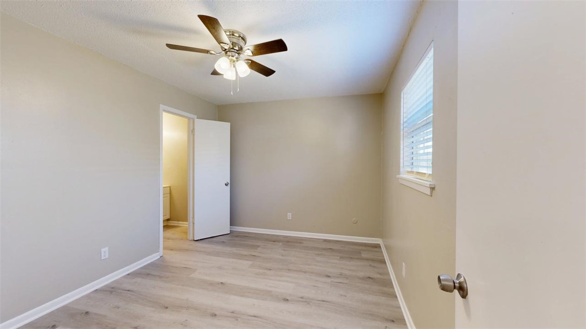500 Foch Street, Unit 16 Bryan, TX 77801 - Photo 6 of 15 wooden floor in an empty room with a window