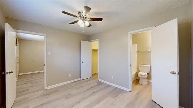 wooden floor in an empty room with a bathroom