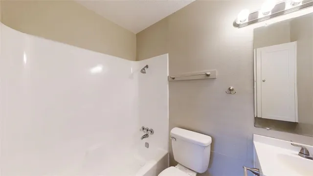 a bathroom with a toilet sink and shower
