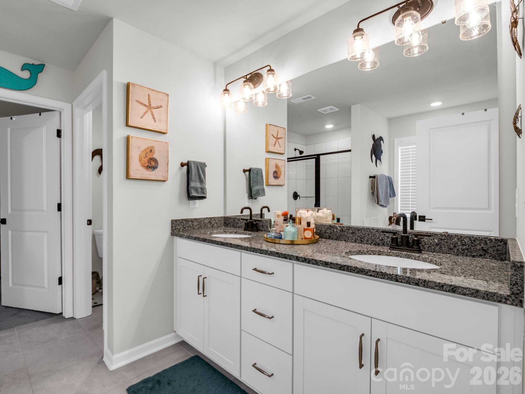 383 Fox Cove Road Hendersonville, NC 28792 - Photo 19 of 34 a bathroom with a granite countertop double vanity sink a mirror and shower