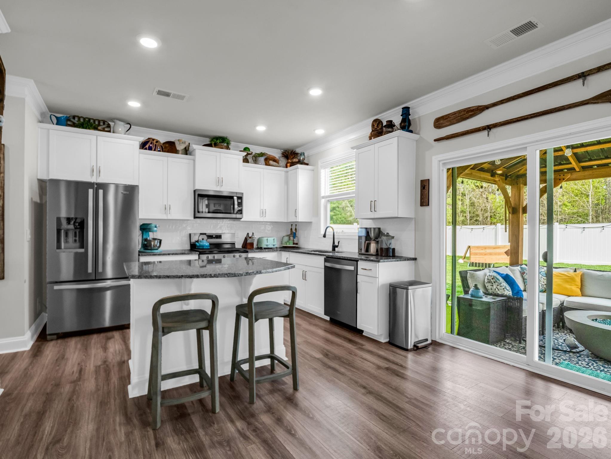 383 Fox Cove Road Hendersonville, NC 28792 - Photo 8 of 34 a kitchen with stainless steel appliances granite countertop a refrigerator a stove top oven a sink dishwasher and white cabinets with wooden floor