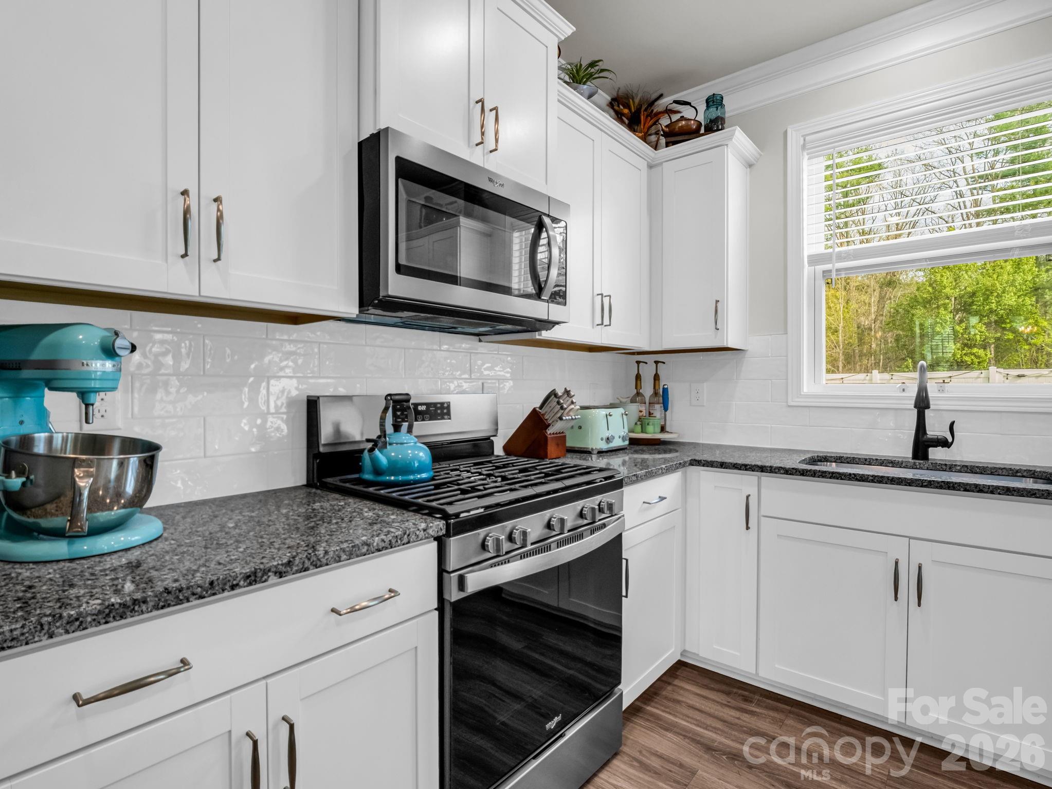 383 Fox Cove Road Hendersonville, NC 28792 - Photo 10 of 34 a kitchen with granite countertop white cabinets white appliances and a granite counter tops
