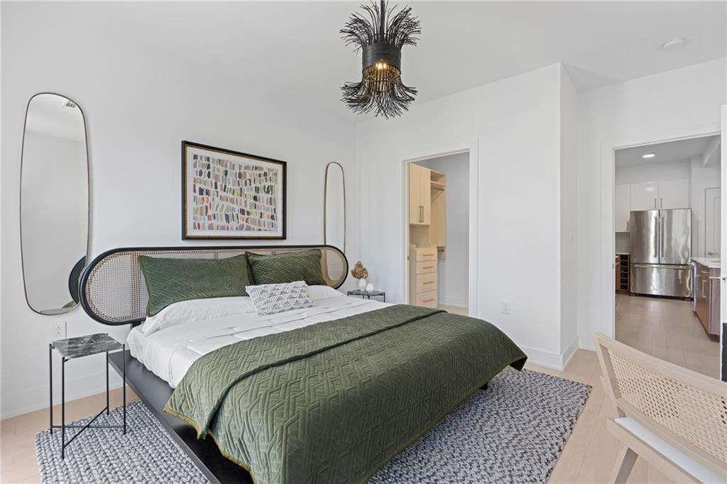 775 Juniper Street Northeast, Unit 212 Atlanta, GA 30308 - Photo 10 of 41 a bedroom with a bed a mirror and paintings on the wall