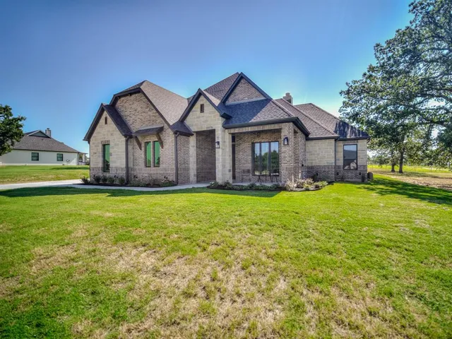 a front view of a house with a yard outdoor seating and garage