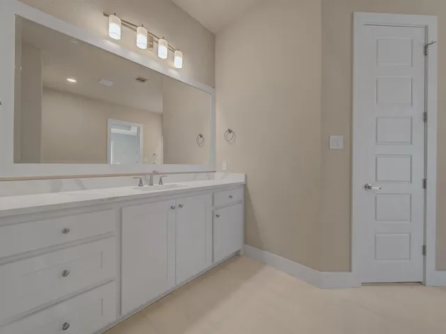 a spacious bathroom with a double vanity sink and a mirror