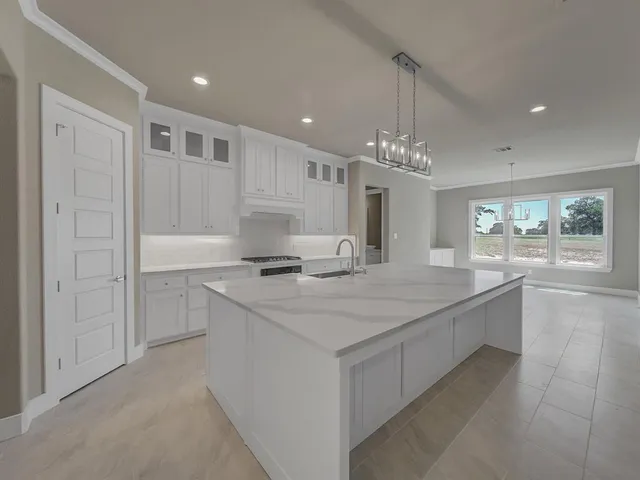 a large kitchen with kitchen island a sink stainless steel appliances and window