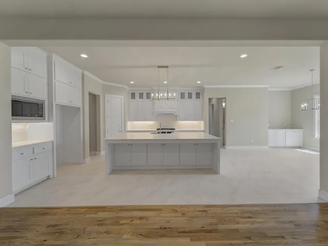 a large kitchen with stainless steel appliances kitchen island a large counter top and a stove top oven