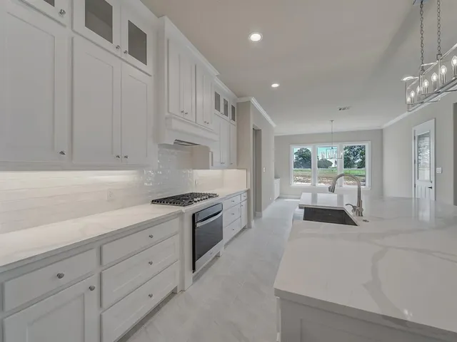 a kitchen with white cabinets and appliances