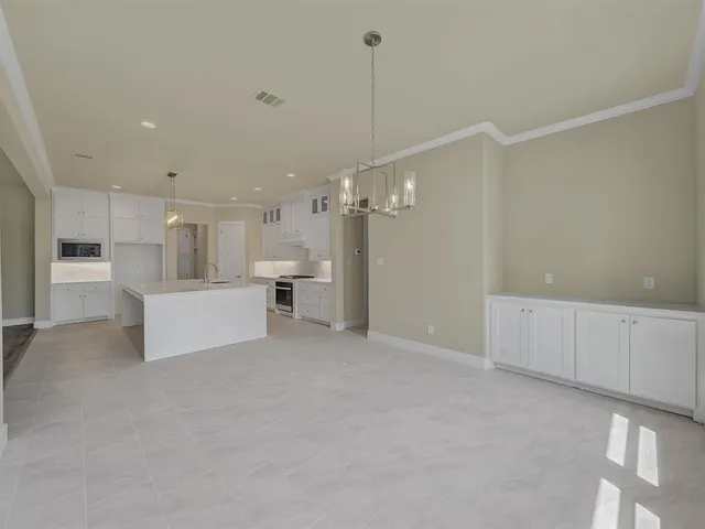 a view of a kitchen with white cabinets and white appliances