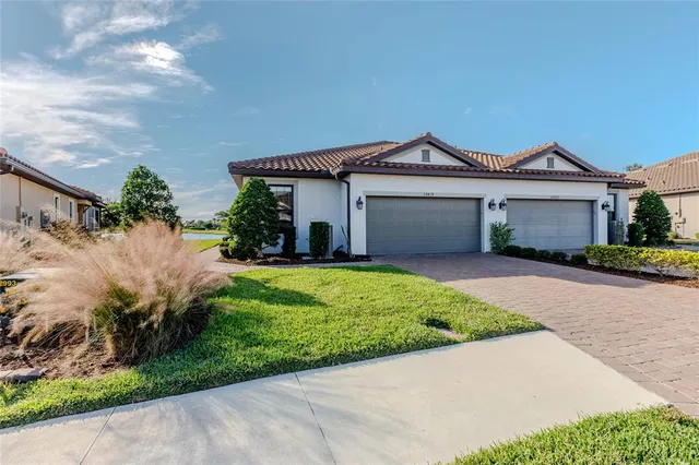 a view of a front of house with a yard and potted plants