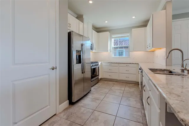 a kitchen with stainless steel appliances granite countertop a refrigerator and a stove top oven
